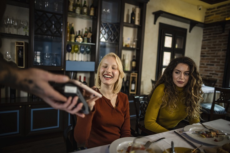 Two Restaurant Loyalty Program members paying their bill.