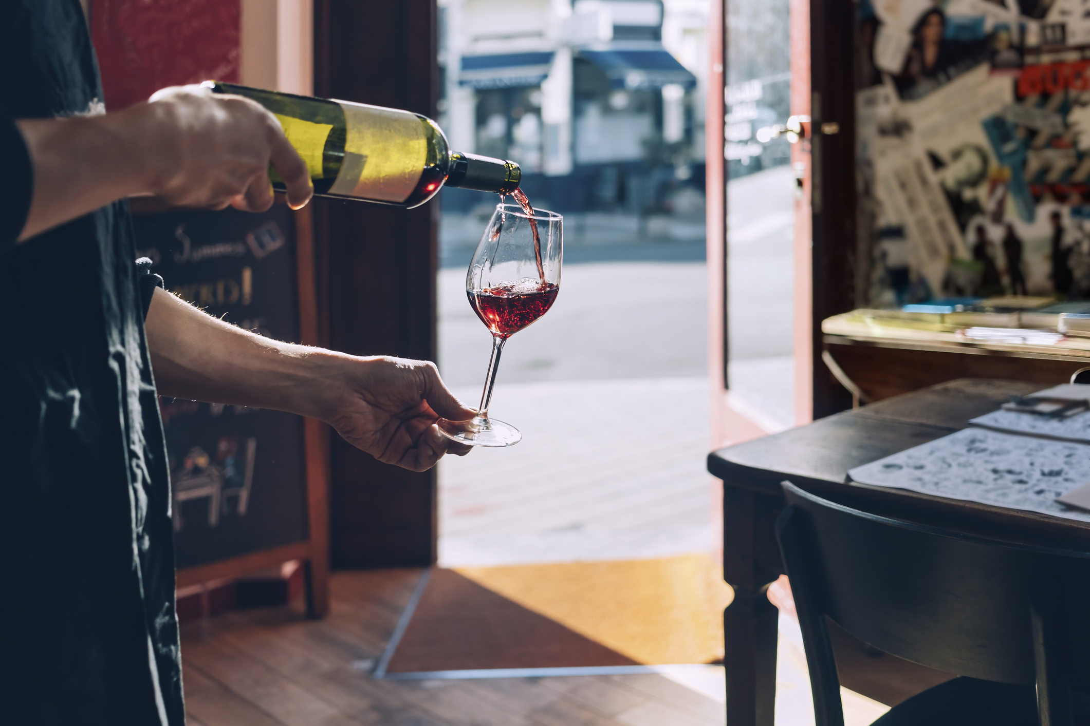 photo: sommelier pouring a glass of wine in a rustic tasting room